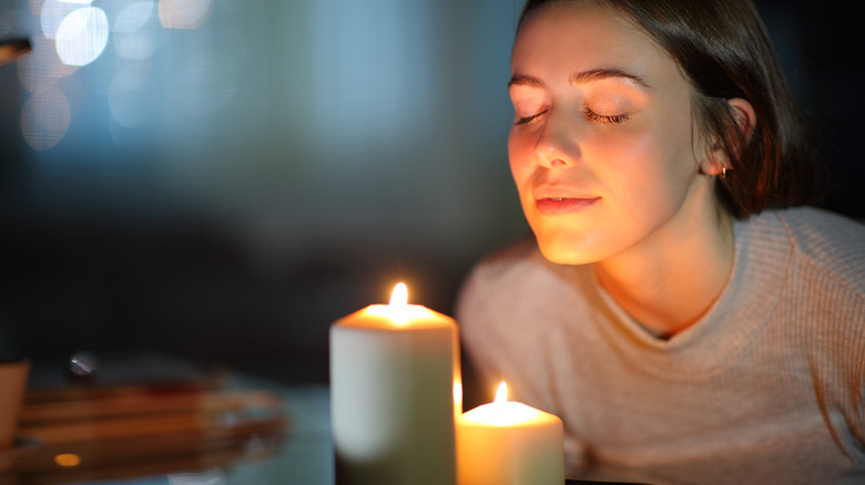 woman smelling candles