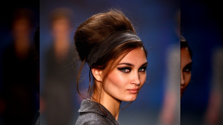 A model with a beehive hairdo on a cat walk