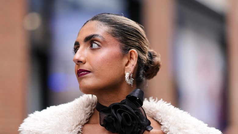 A woman with a bun and a scarf tied around her neck.