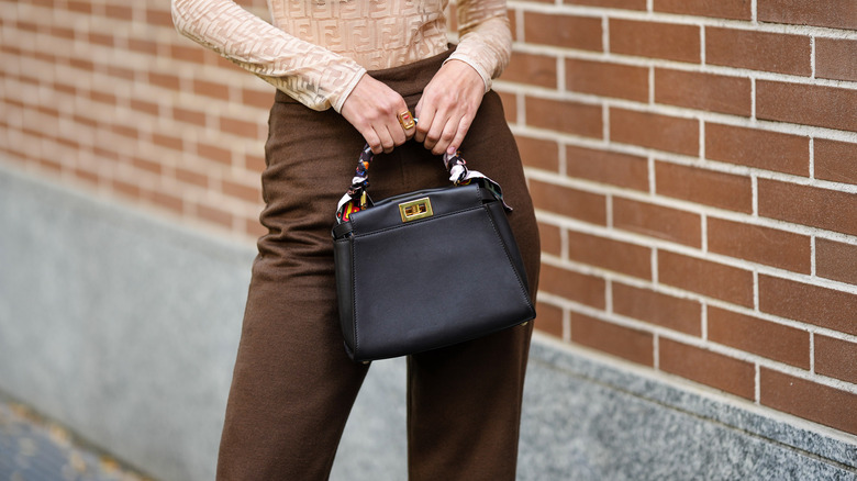 Woman holding top handle bag