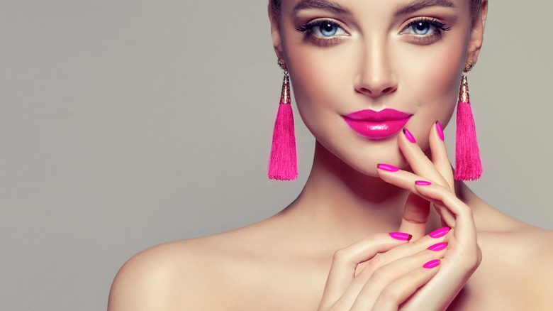 A woman with bright pink jewelry