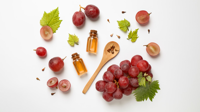 Grapes and grapeseeds scattered with a wooden spoon and vials