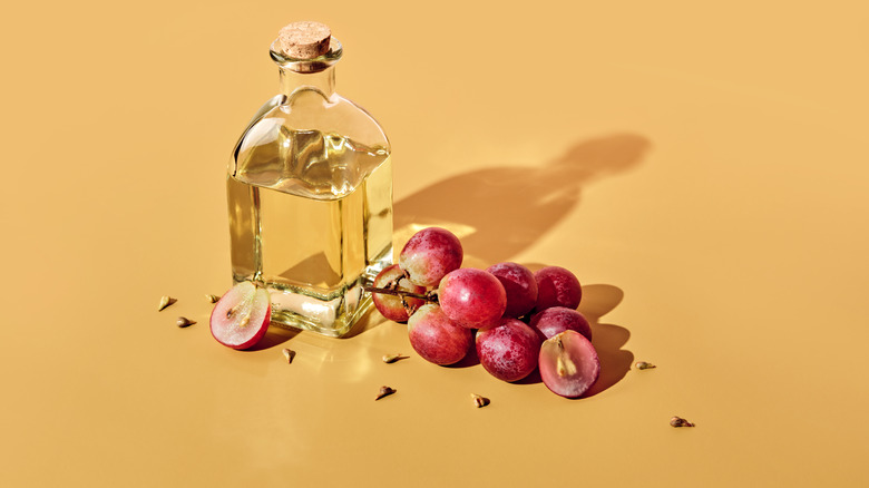 Grapes pictured with a bottle of grapeseed oil