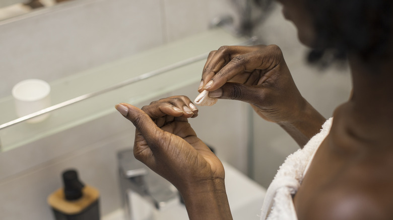 woman removing nail polish