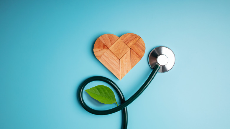 A wooden heart pictured with a stethoscope