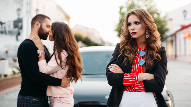 Woman looking jealously at a happy couple