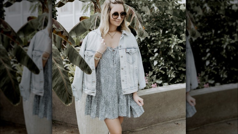 woman wearing denim jacket over blue dress