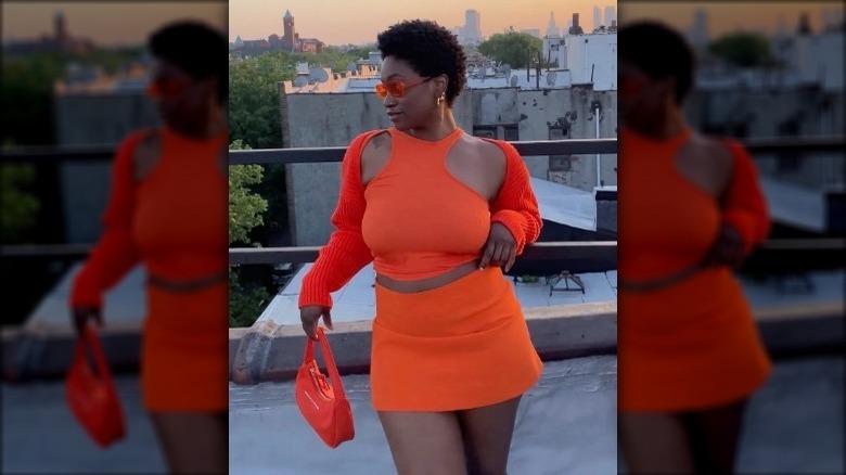 woman wearing orange dress and crop top with red shrug