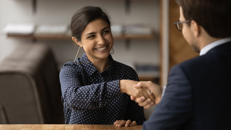 woman shaking hands with man