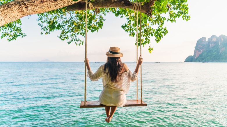 woman on tree swing over water