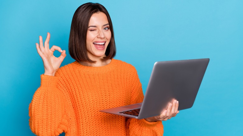 smiling, winking woman with laptop