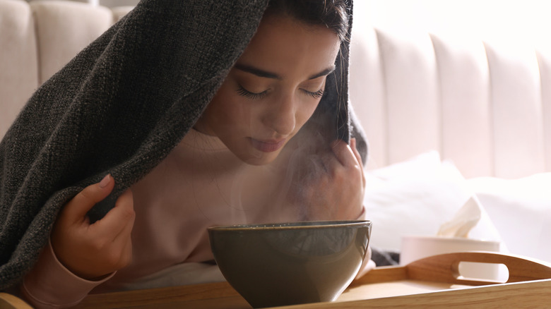 woman steaming face over bowl