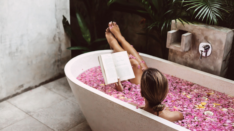 Woman in the bathtub reading a book