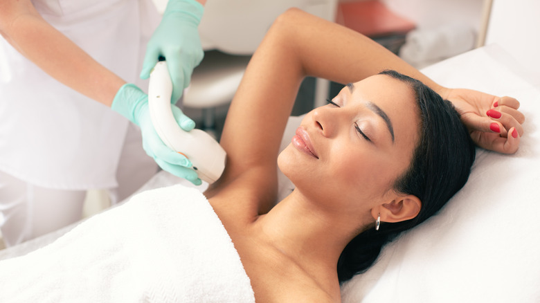 Woman undergoing laser hair removal treatment