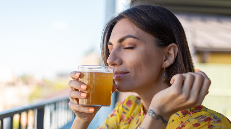 woman drinking a glass of kombucha