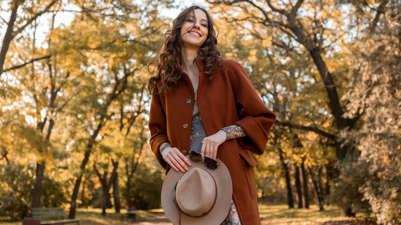 woman walking through fall foliage