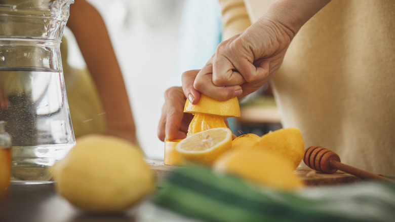 woman squeezing lemon to make juice