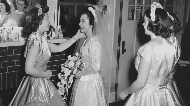 1950s bridesmaids helping bride get ready 