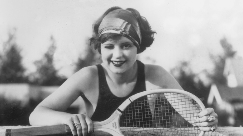 Clara Bow winking with tennis racket