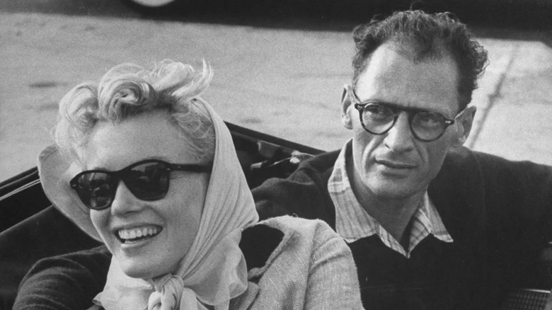 Marilyn wearing cat-eye sunglasses, then-husband Arthur Miller