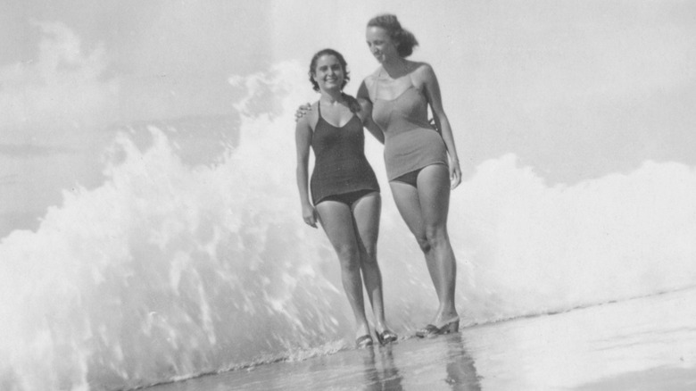 Women at the beach wearing 50s swimsuits