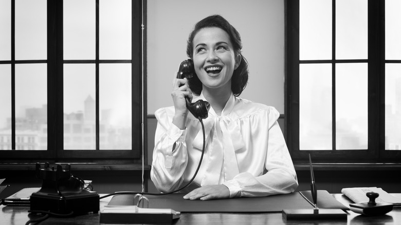 Woman smiling at desk on phone