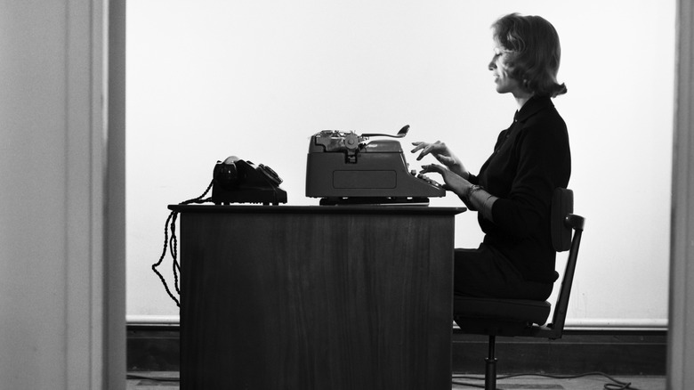 Woman typing and wearing a suit