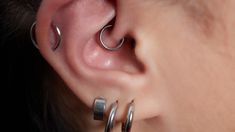 Close up of an ear with many piercings