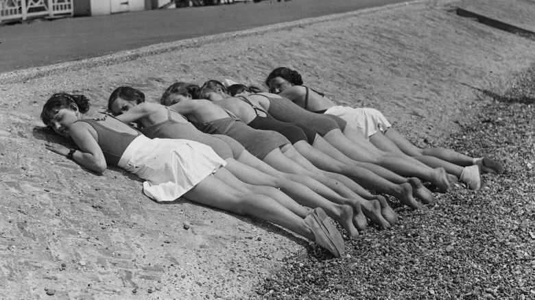 row of women sunbathing