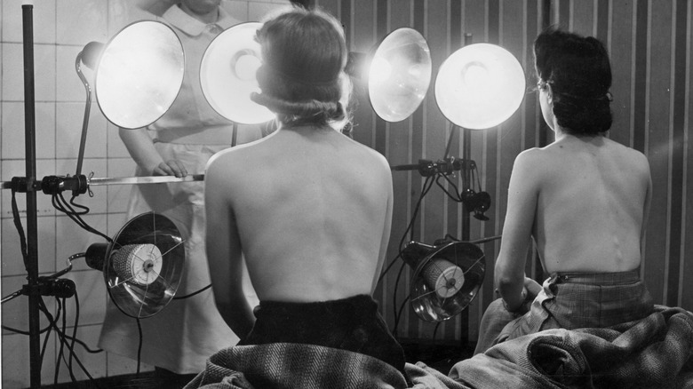 Two 1940s women use sunlamps 