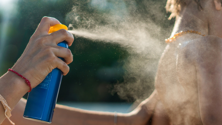 Spraying on sunscreen