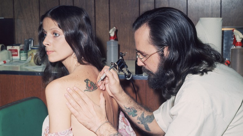 tattooist inking woman