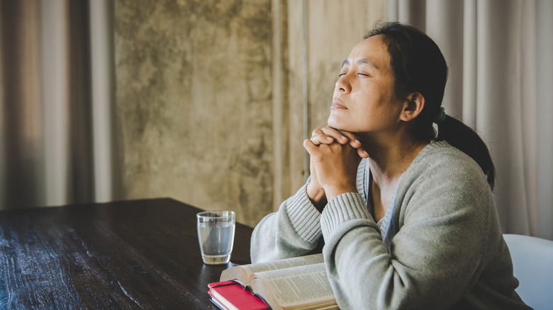 Woman praying at table