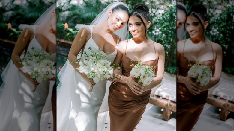 Vanessa Hudgens posing in her wedding dress next to her bridesmaid