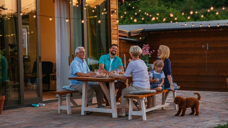 Multigenerational family dining in backyard
