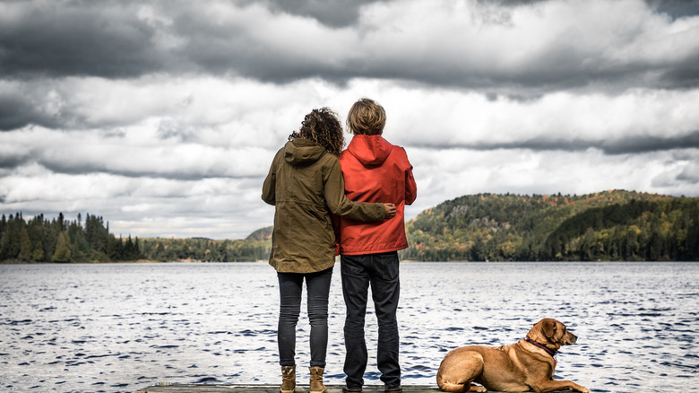 Couple embracing beneath storm clouds