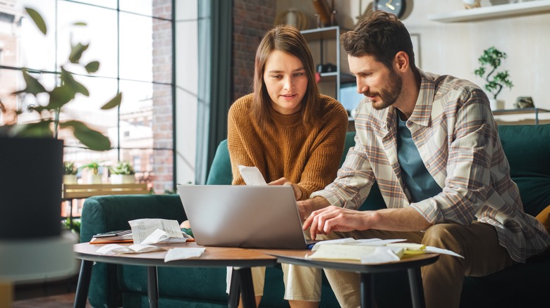 Couple at computer going over financial documents