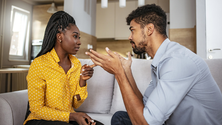 Man gesturing emphatically at woman