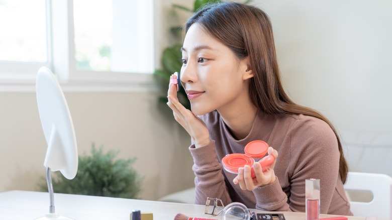 Woman applying blush