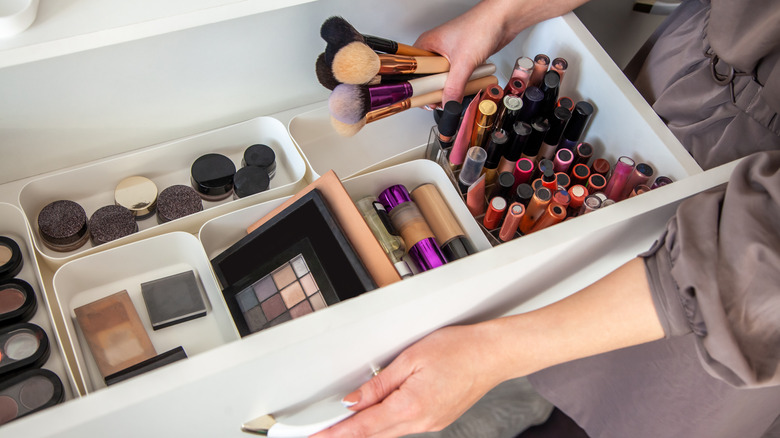 Woman gathering makeup brushes