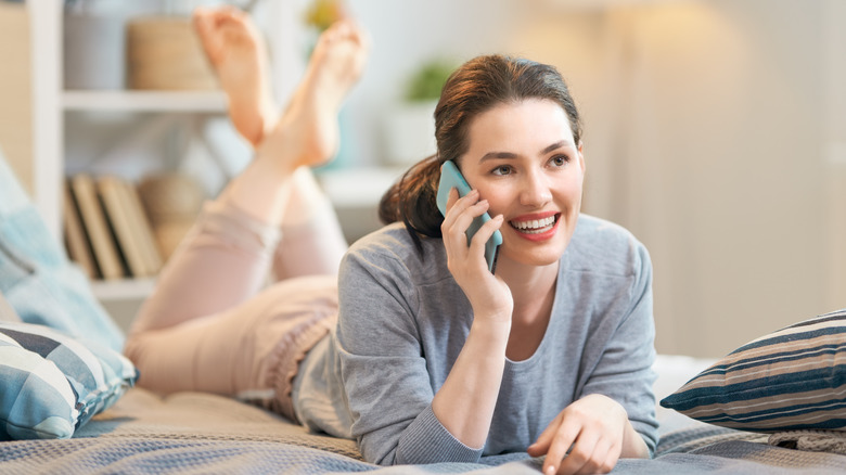 woman on bed talking on phone