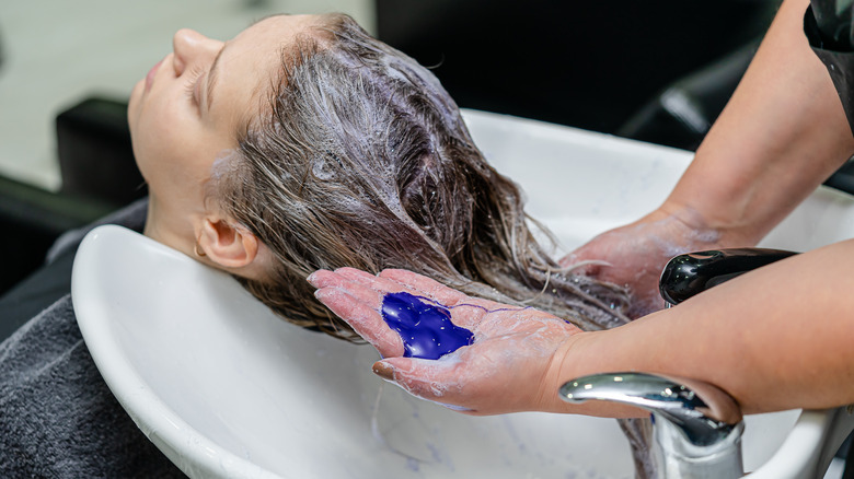 Stylist using purple shampoo 