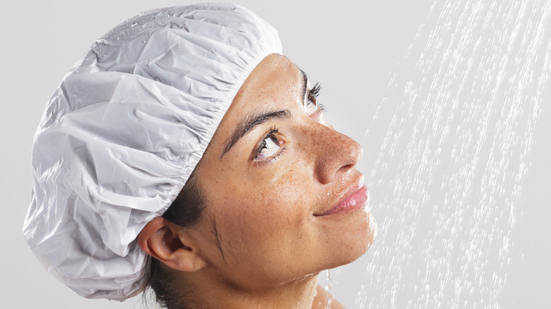 Woman in shower keeping hair dry