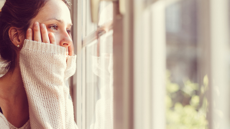 Sad woman staring out of window