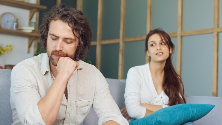 Woman looking apprehensively at scowling man