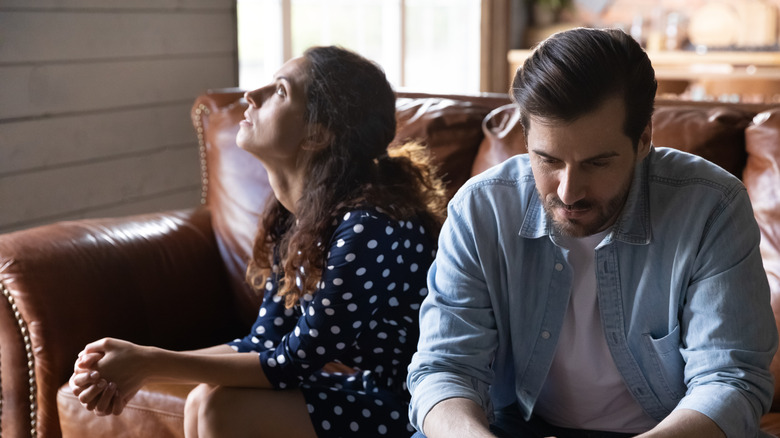 Couple sitting on couch upset