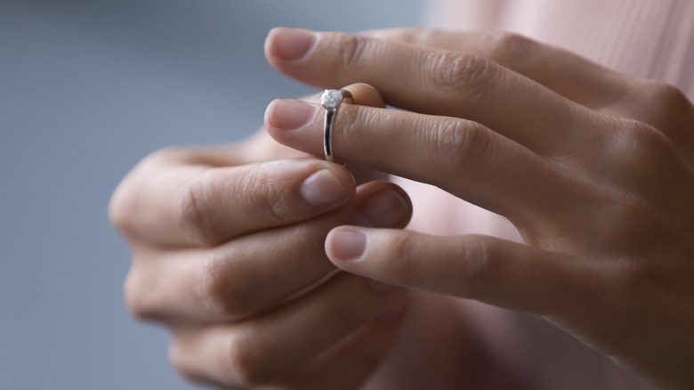 Close up of woman's hands as she removes wedding ring