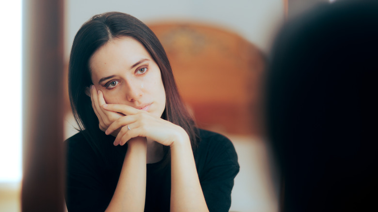 Woman looking sad in mirror