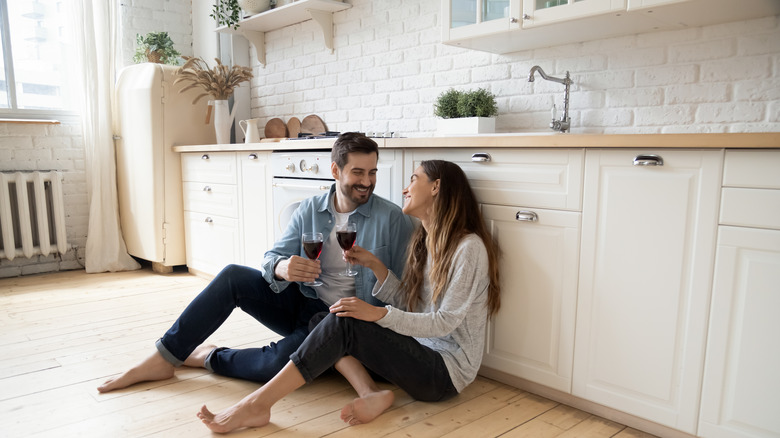 couple sitting on floor drinking wine 