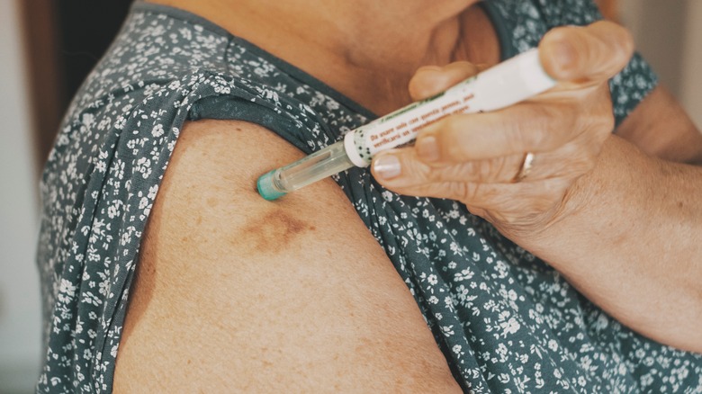 Woman giving herself an injection